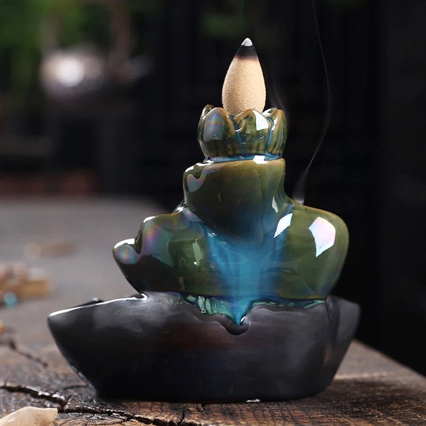 Teal-green glossy ceramic lotus burner with black lotus tray close-up