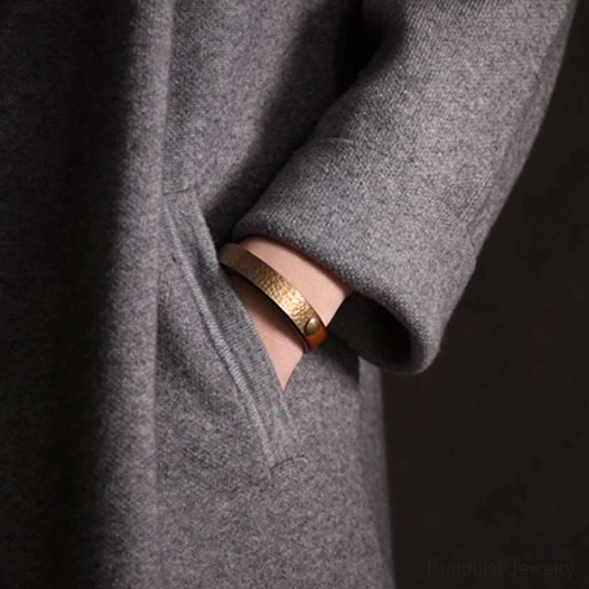 Textured leather and hammered brass bangle bracelet designed for wealth attraction and energetic balance