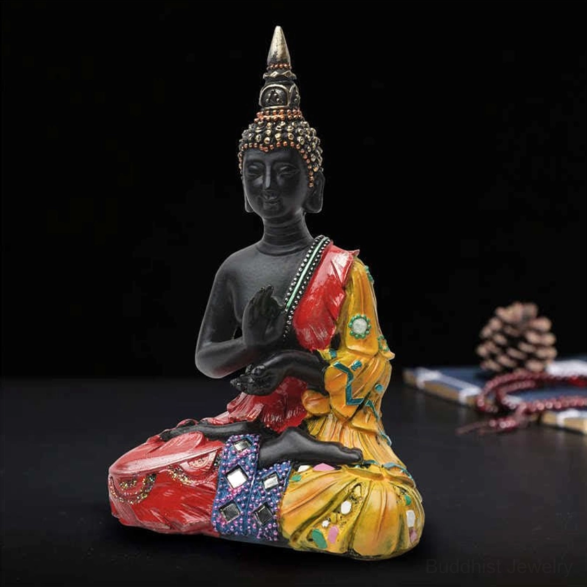 Thai Buddha resin statue three-quarter view with spired crown, colorful decorative robes and prayer beads