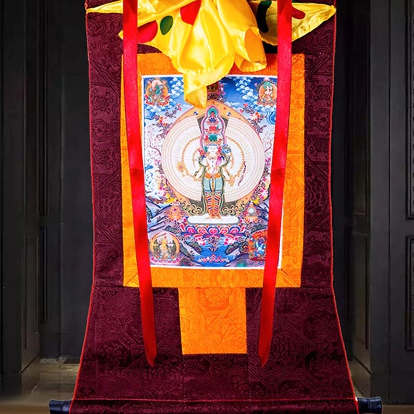 Thousand-armed Avalokitesvara thangka with multi-colored artwork in dark wooden interior space