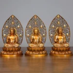 Three handcrafted copper Buddha statues displayed together on wooden table - Sakyamuni Amitabha and Medicine Buddha figurines with ornate lotus bases