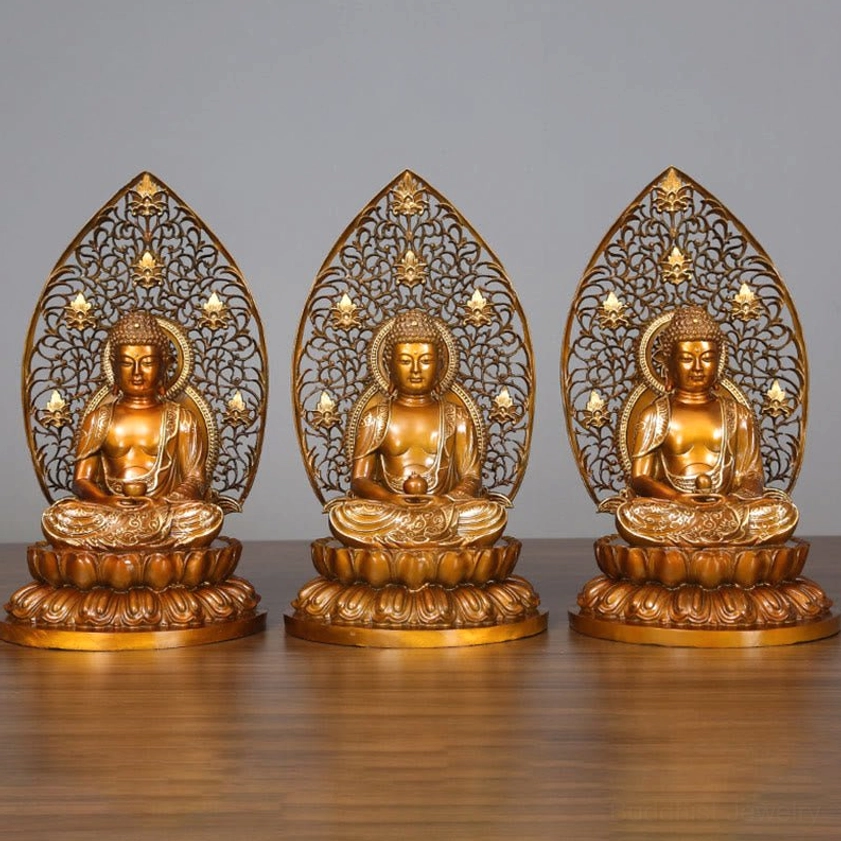 Three handcrafted copper Buddha statues displayed together on wooden table - Sakyamuni Amitabha and Medicine Buddha figurines with ornate lotus bases