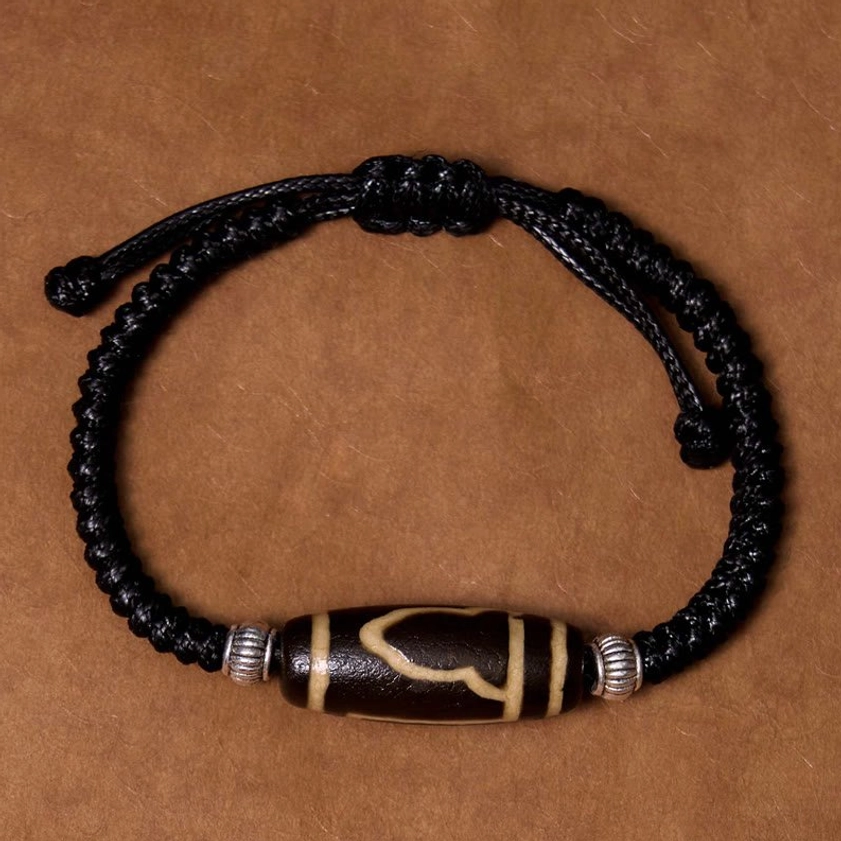 Three-eye dzi bead bracelet overhead perspective displaying three sacred eyes and overall circular design