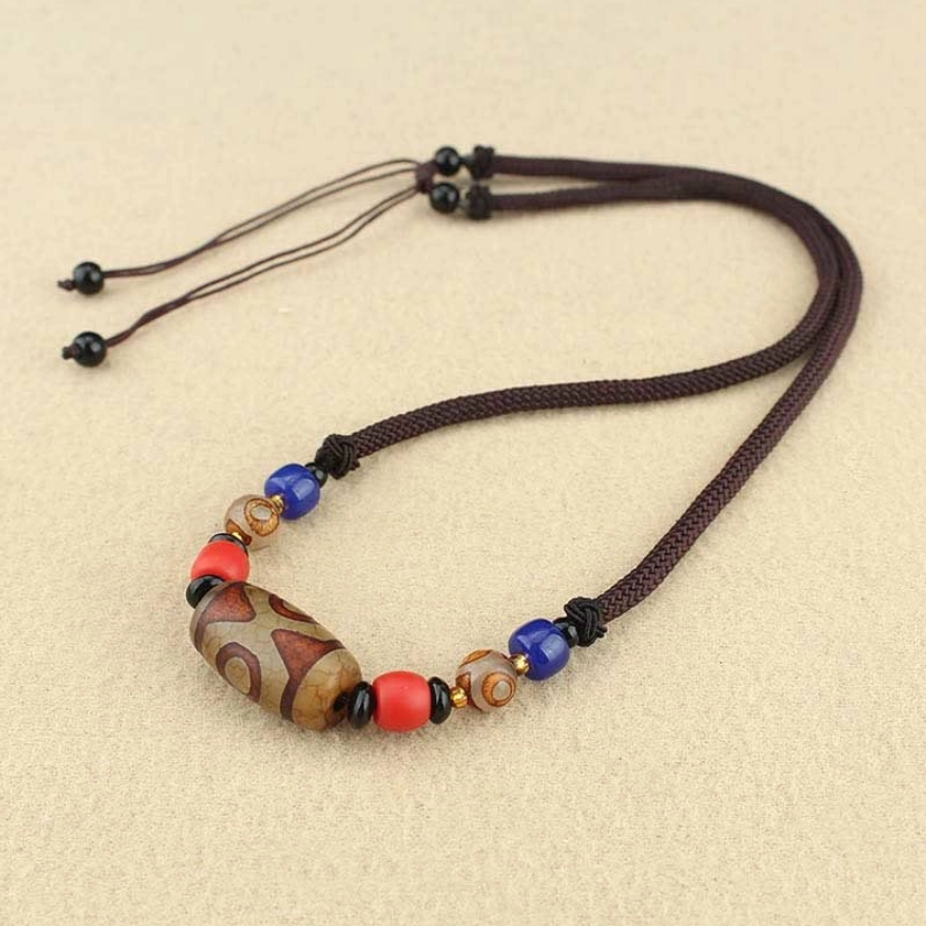 Three-eye Dzi bead Buddhist pendant necklace closeup showing career wealth and longevity protection symbolism