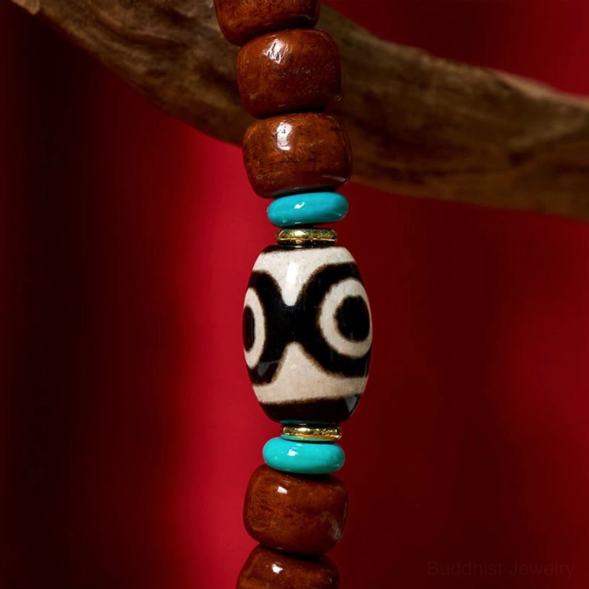 Sacred three-eye Dzi bead bracelet showing craftsmanship details including bone beads, silver clasp, and turquoise stone spacers