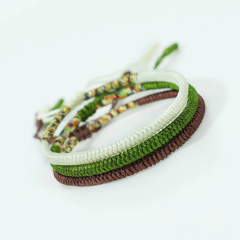Three-piece Buddhist luck bracelet collection stacked together, displaying multicolored woven knots and braided spiritual amulet design