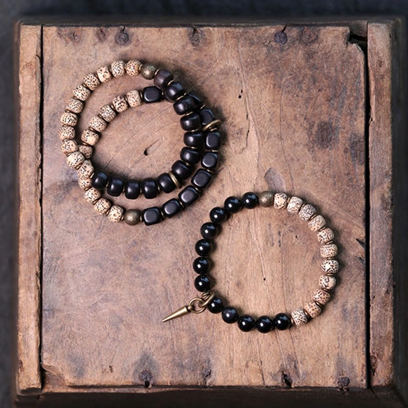 Three Buddhist peace bracelets set with bodhi seeds obsidian and brass hardware on vintage wooden box