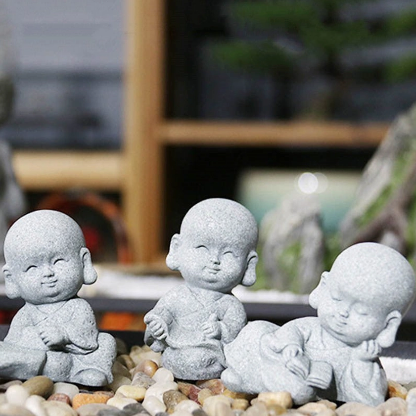 Three-piece handmade monk Buddha statue set with different poses on pebble tray wooden shelf backdrop