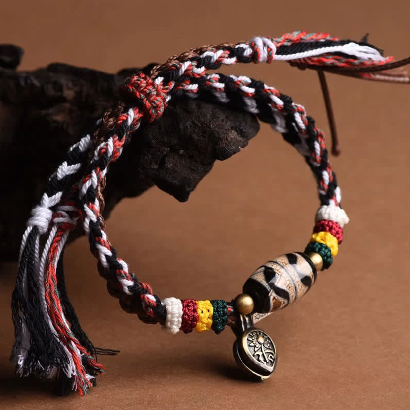 Hanging Tibetan friendship bracelet with red black white woven cord, round metal charm, and colorful spacer beads