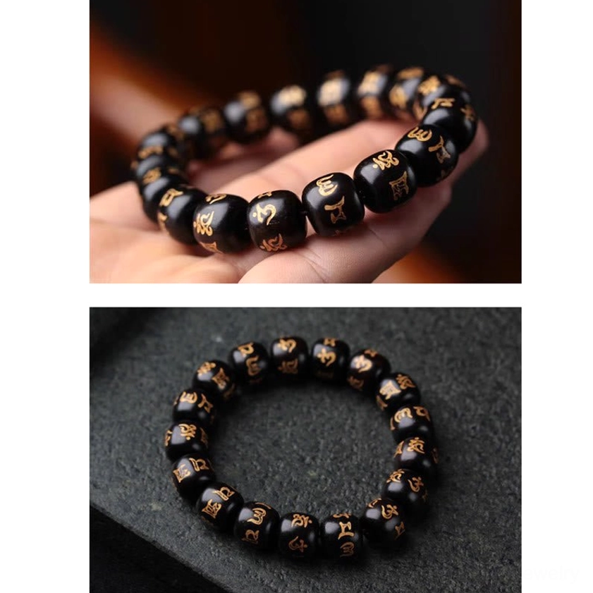 Delicate ebony wood mantra bracelet held in human palm, showing fine bead craftsmanship and golden scripture details