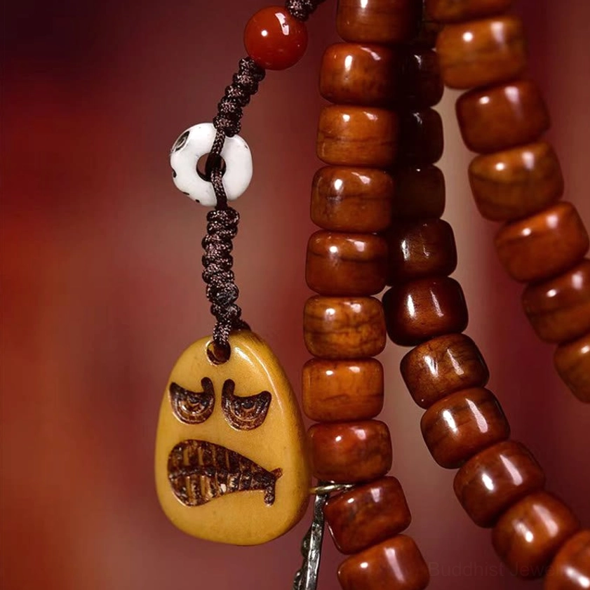 Reddish-brown barrel bone beads with white skull charm, grimace pendant, and braided brown elastic cord of Buddhist prayer mala bracelet