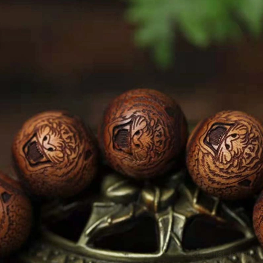 Macro photograph of tiger head carving on rosewood beads, showcasing intricate engraving detail and rich natural wood grain