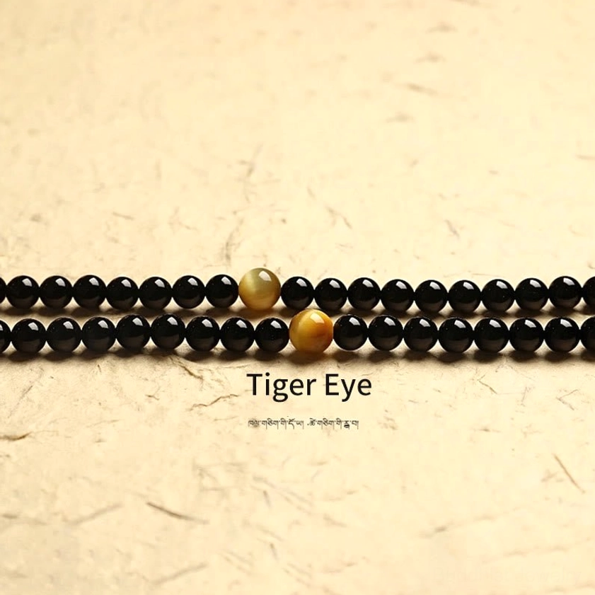 Tiger eye and black onyx mala beads macro detail showing stone quality and natural patterns