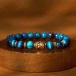Lake Blue Tiger Eye Buddha Bracelet with Gold-Toned Accents – Top-Down View