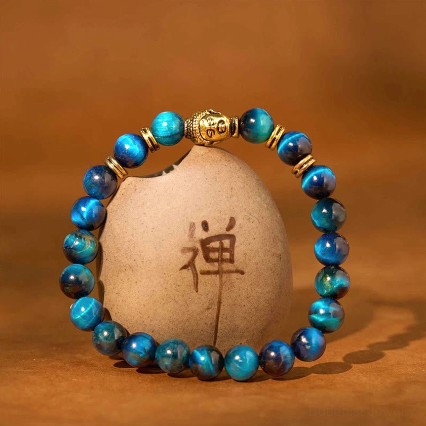 Multicolor tiger eye bracelet arranged on decorative ceramic stone with Buddhist character
