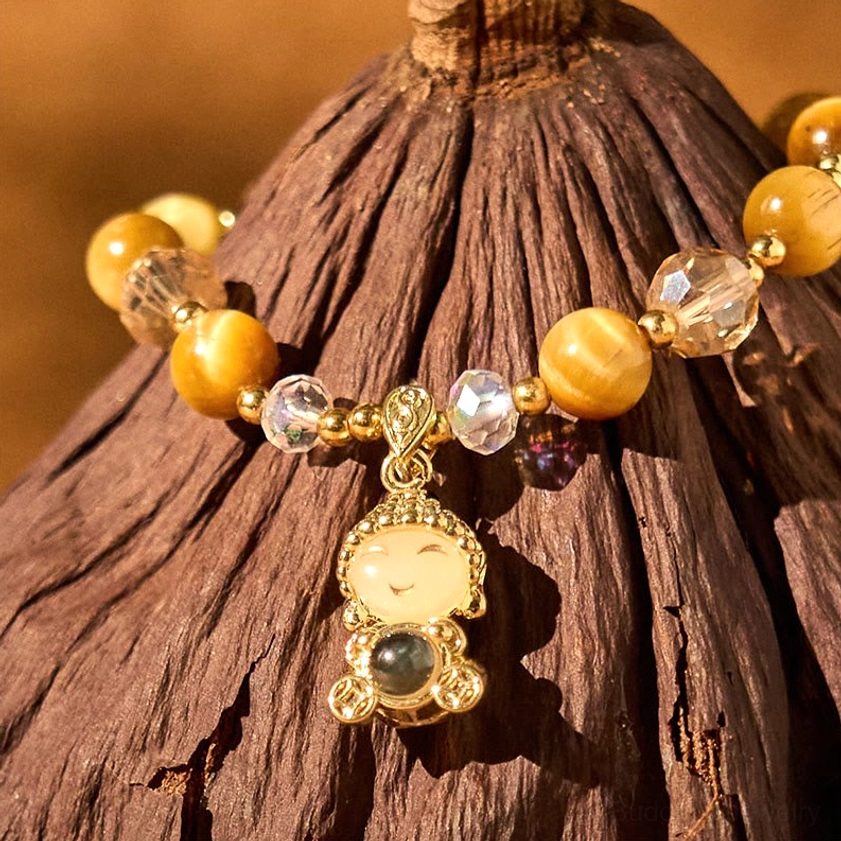 Close-up detail of tiger eye Buddha bracelet showing gilded Buddha pendant and crystal stone clarity