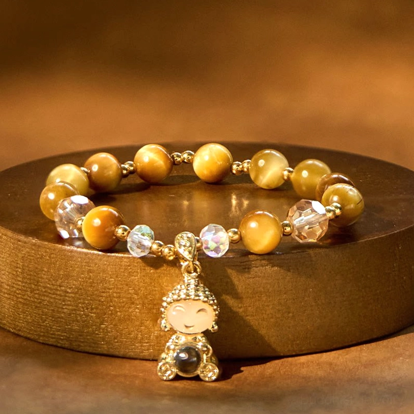 Yellow tiger eye Buddha meditation bracelet on wooden tray with warm golden tone highlighting
