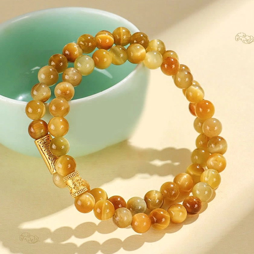 Tiger eye stone bracelet with decorative gold charms and beads arrangement