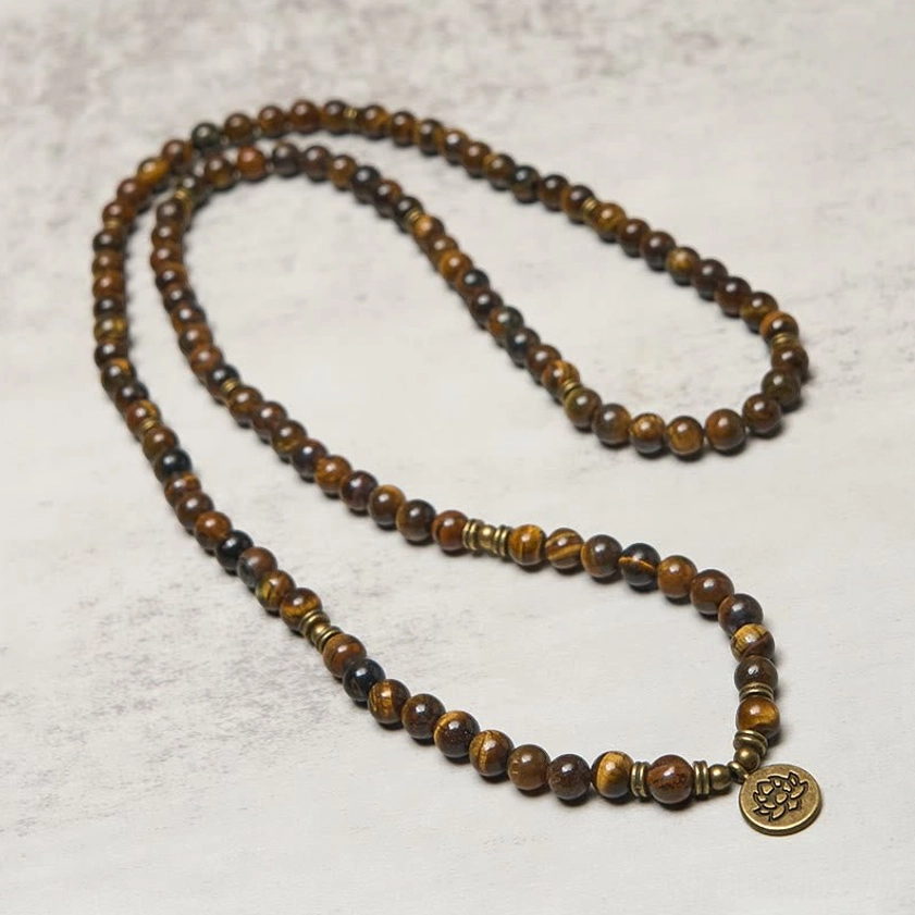 Long strung tiger eye buddhist mala with bronze lotus pendant and natural stone beads continuous strand overhead photography