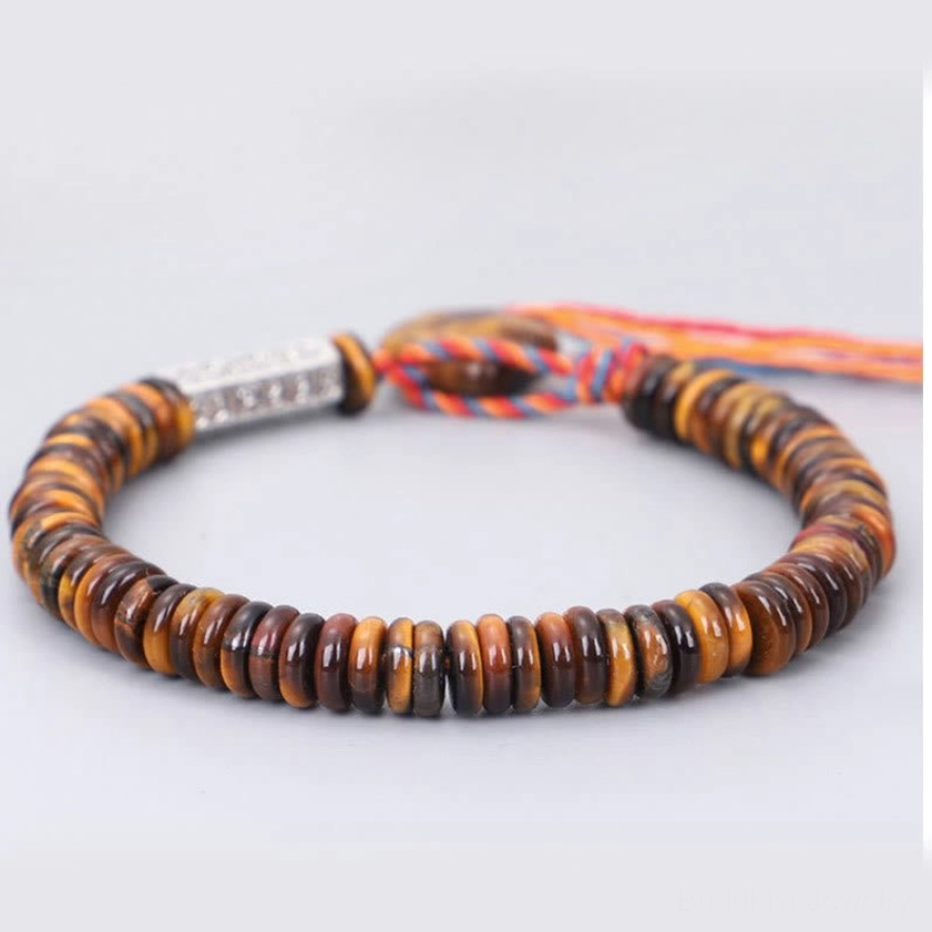 Tiger eye mani padme hum Buddhist bracelet with disc beads and engraved silver charm on neutral background