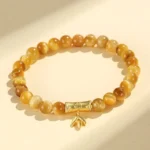 Tiger eye buddhist protection bracelet with gold fu character charm, overhead flat lay view