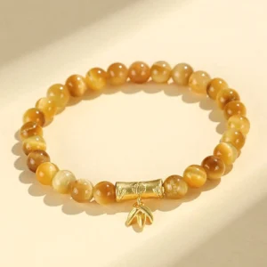Tiger eye buddhist protection bracelet with gold fu character charm, overhead flat lay view