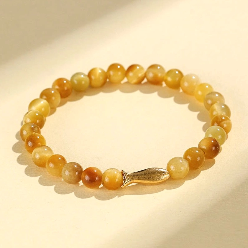 Tiger eye buddhist bracelet with gold koi fish charm overhead flat lay