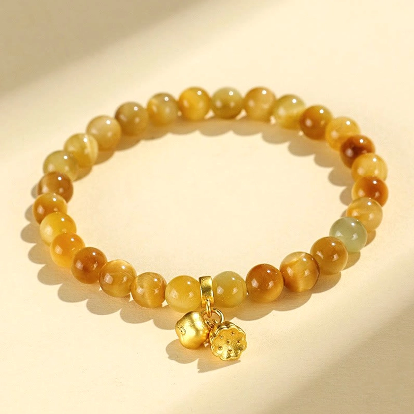 Tiger eye buddhist bracelet with gold lotus charm overhead flat lay