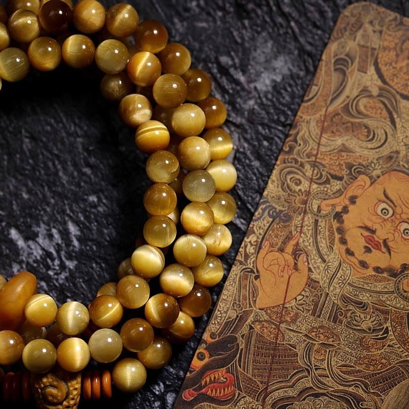 Polished golden Tiger Eye mala beads close-up detail shot showing chatoyant striping and quality craftsmanship
