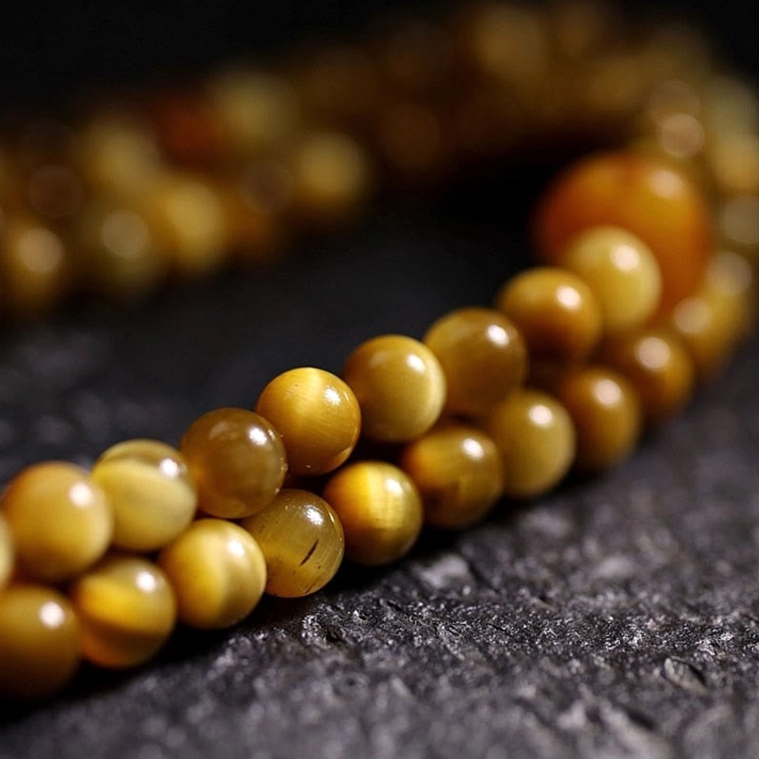 Macro photography of 108 Tiger Eye prayer beads showing uniform round shape and rich golden-brown coloring