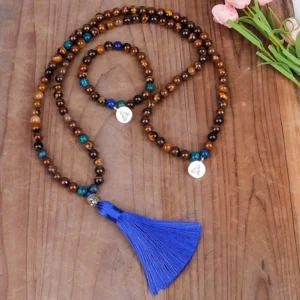 Tiger eye Buddhist mala beads set with blue accents and metal Buddha charm on wooden table