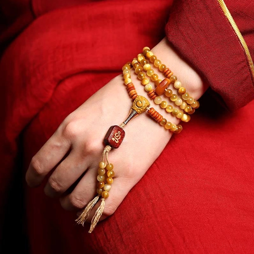 Tiger Eye Mala Bracelet worn on wrist with copper Vajra charm and carved wooden guru bead, modeled view