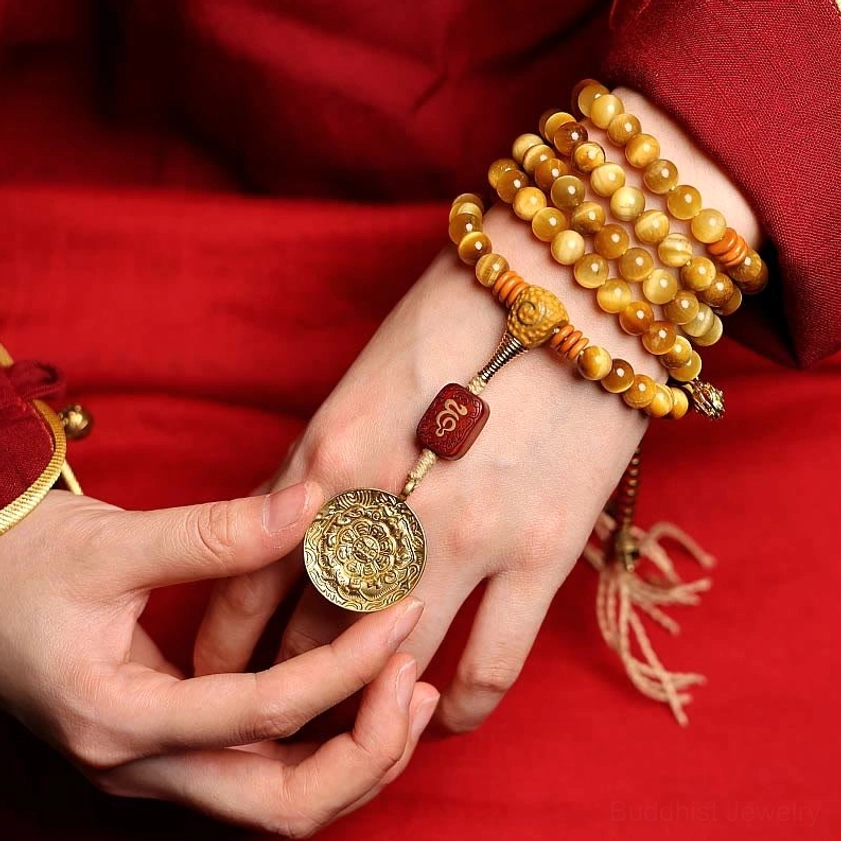Multi-wrap Tiger Eye Mala Bracelet with copper Vajra and carved wooden charm worn on wrist, detail view