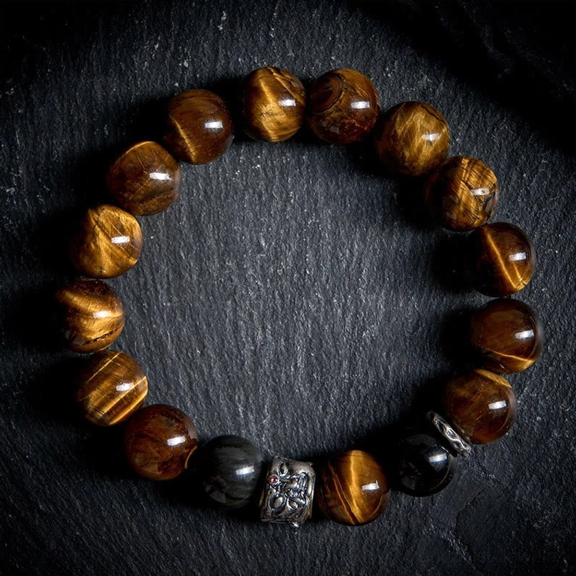 Close-up of beaded protection bracelet showing tiger eye stone beads, black obsidian beads, and silver Buddha head charm