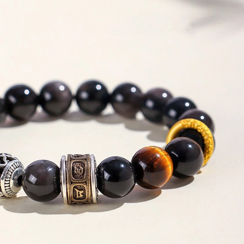 Macro close-up of tiger eye stone and silver carved beads in Om Mani Padme Hum meditation bracelet