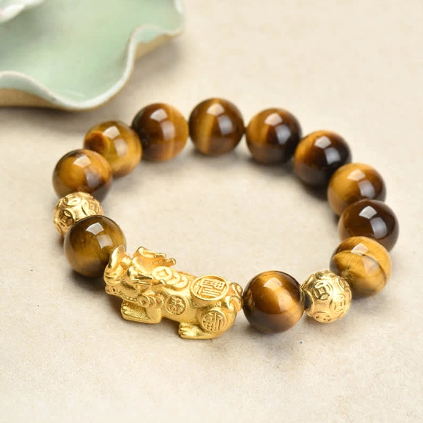 Natural tiger eye beads with gold Pixiu wealth charm, top-down product shot