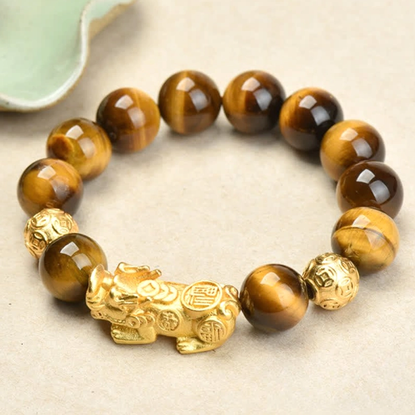 Tiger Eye Pixiu bracelet with Fu character and Om Mani Padme Hum charm, flat lay view