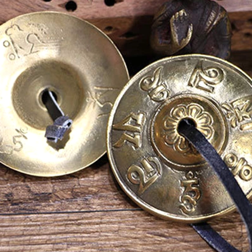 Extreme close-up of tingsha bell showing embossed mantras floral center and traditional craftsmanship