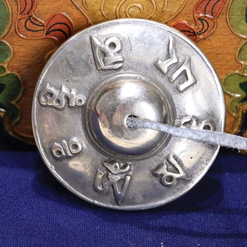Buddhist tingsha bell engraved with om mani padme hum six true words mantra, white copper finish, leather cord attachment