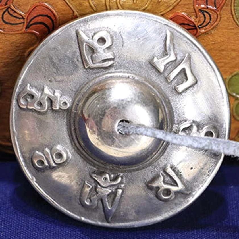 Single buddhist tingsha cymbal featuring six true words full engraving, polished copper finish, carved wood backdrop