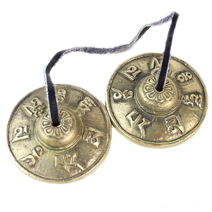 Pair of brass tingsha cymbals connected by long leather strap on white background