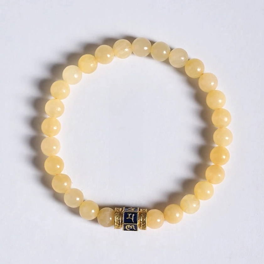 Golden topaz mala bracelet with soft shadows top-down flat lay showing rounded uniform light yellow beads