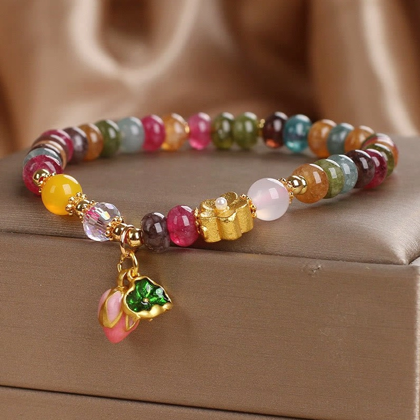 Tourmaline lotus beaded bracelet with multicolor stones and gold flower accent, left side jewelry display view