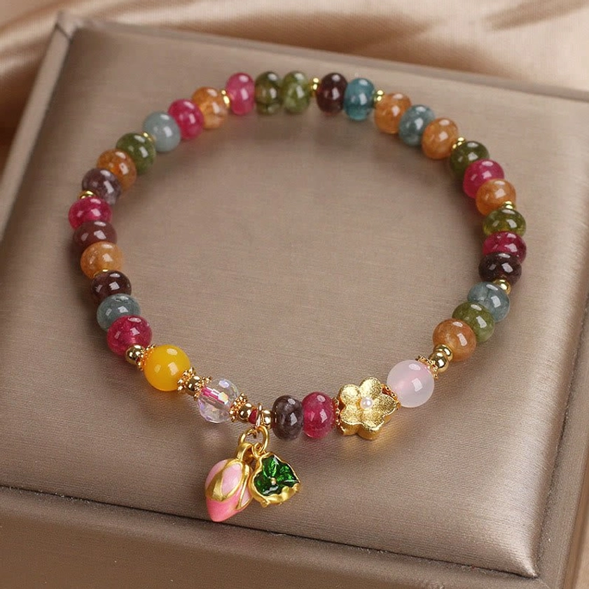 Tourmaline lotus wisdom bracelet with mixed colored beads and pink lotus seedpod drop charm in satin presentation box