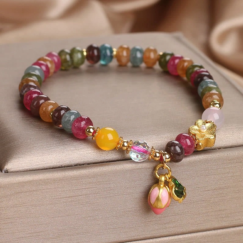 Tourmaline lotus wisdom bracelet featuring mixed stone beads, gold accents, and delicate pink lotus bud charm detail