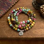 108 tourmaline Buddhist prayer mala bracelet with silver lotus pendant, multicolor natural beads flat lay