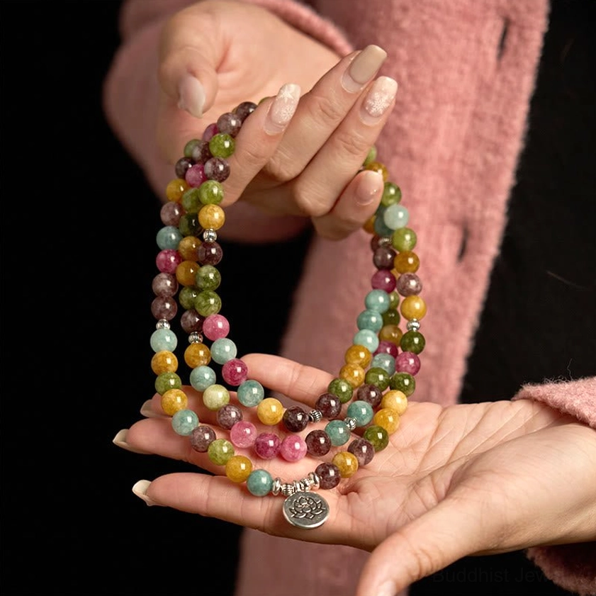 Palm display of tourmaline 108 mala beads showing multicolor natural tourmaline stones and lotus accent