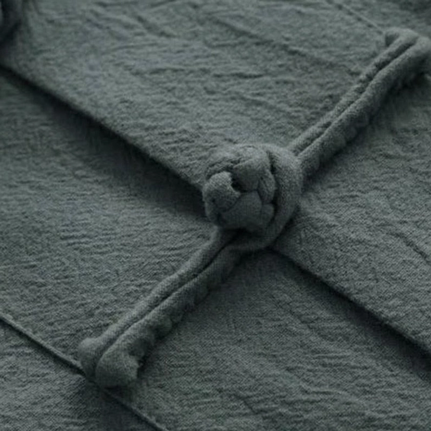 Detailed view of traditional Chinese frog button knot on linen-cotton fabric with authentic texture