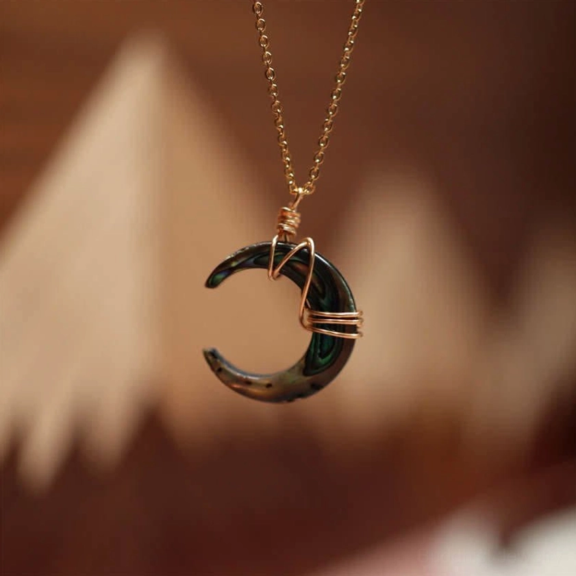 Black Tridacna crescent moon pendant necklace with gold wire wrapping and delicate chain, elegant Buddhist protective jewelry piece