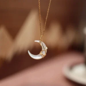 White Tridacna crescent moon pendant necklace with gold wire wrapping, front overhead close-up view showing intricate craftsmanship and delicate gold chain